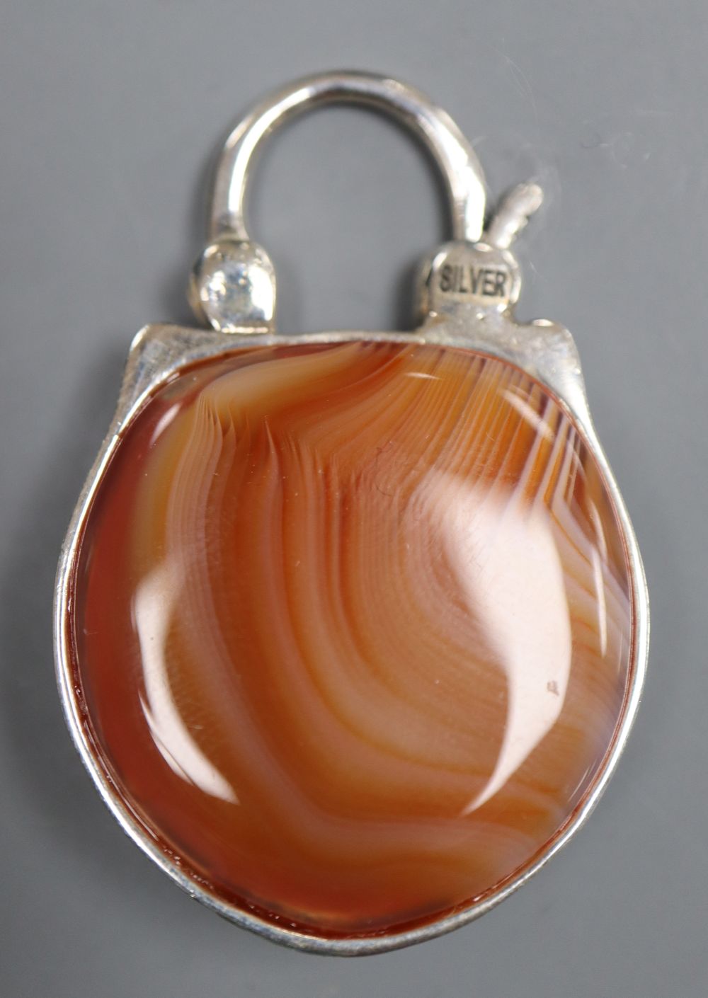 A modern white metal (stamped silver) and agate backed pendant, modelled as the head of an owl, 39mm.